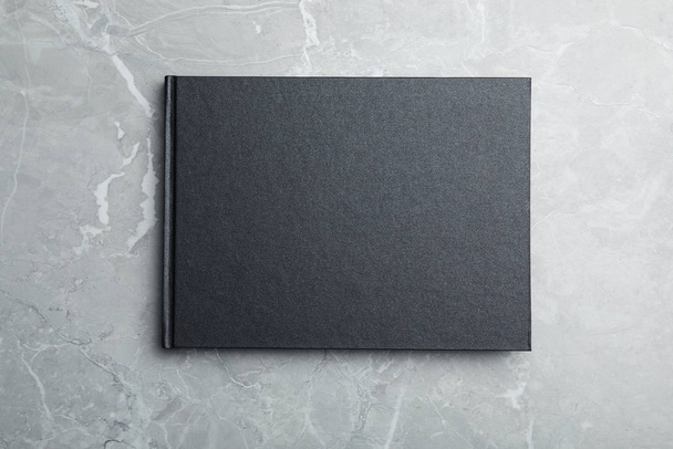 Stylowy czarny notatnik na marmurowym stole, widok z góry - Zdjęcie, obraz