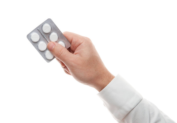 Man hand with pills blister isolated on white background. White shirt, business style. Medicament and food supplement for health care. Pharmaceutical industry. Pharmacy. - Fotoğraf, Görsel