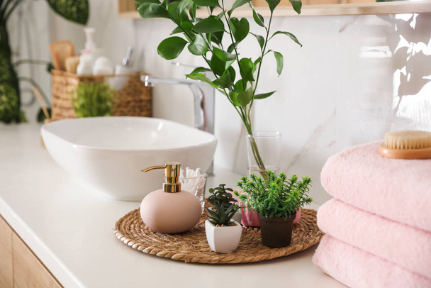 Green plants and toiletries on white countertop in bathroom. Interior design - Foto, imagen