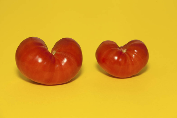 Red tomatoes on a yellow background. Horizontal orientation. - Fotó, kép