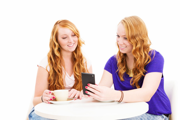 two smiling women looking at a smartphone - Photo, Image
