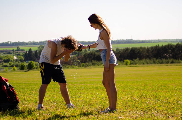 backpackers man and girl on the field - Foto, immagini