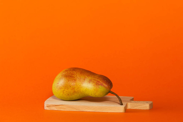 One pear lies on a cutting board. Closeup. Copy space. - Fotó, kép