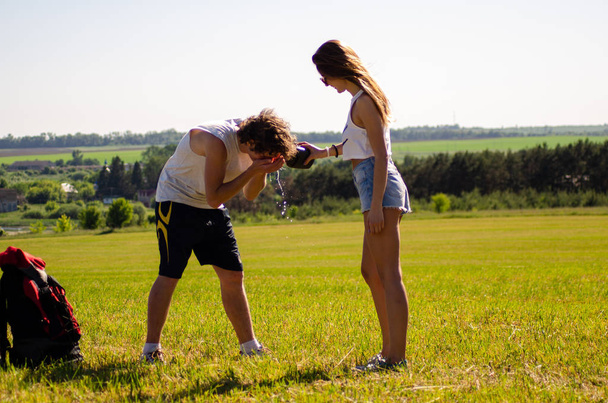 backpackers man and girl on the field - Foto, immagini