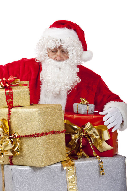 Surprised Santa Claus on knees with big stack of Christmas gift - Fotó, kép