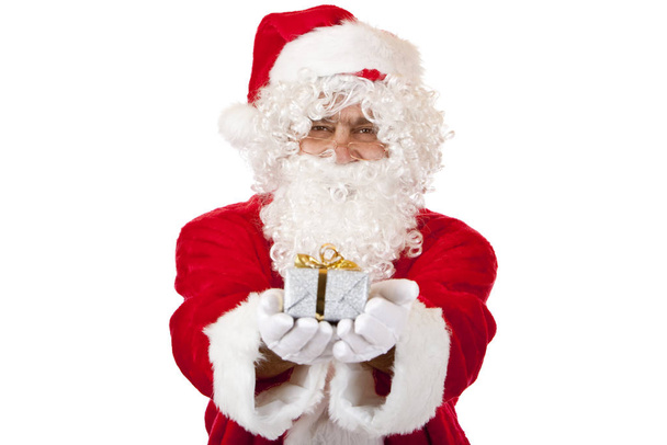 Old happy Santa Claus holding Christmas gift in hands - Photo, Image