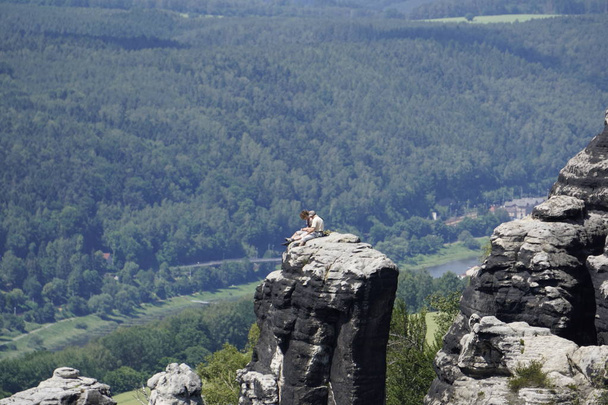 シュランムシュタイン地方の砂岩の岩の上に座っている男と女 - 写真・画像