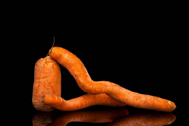 Deformierte Karotten auf schwarzem Hintergrund. horizontale Ausrichtung - Foto, Bild