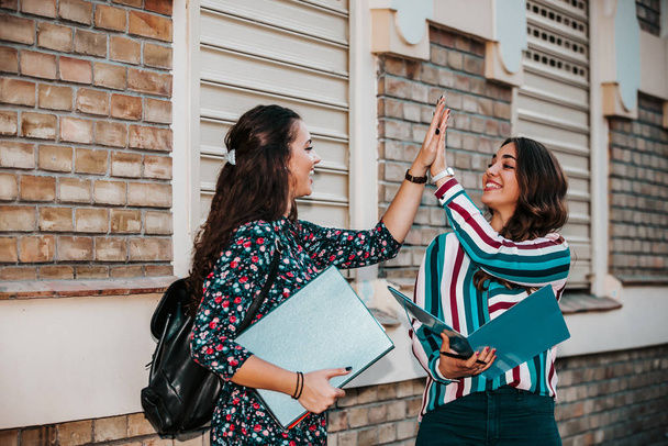 Boldog Női diákok adnak egymásnak ötöt a barátság alatt  - Fotó, kép