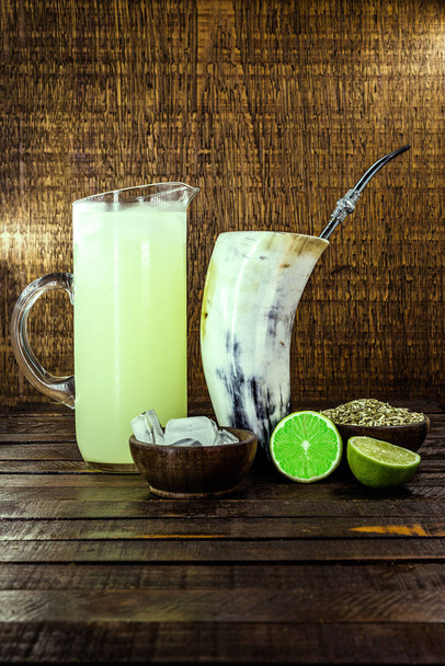 Tereré or Tererê, is a Brazilian drink made with the infusion of yerba mate in cold water. Drink prepared with yerba mate and lemon. - Фото, изображение