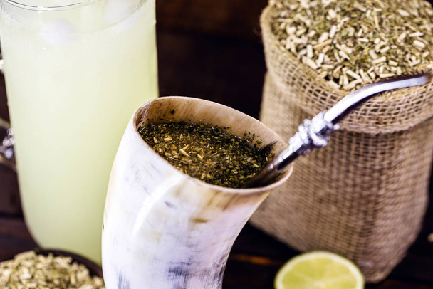 Tereré or Tererê, is a South American drink, consumed in Brazil, Argentina and Uruguay, made with the infusion of yerba mate in cold water. Drink prepared with yerba mate and lemon. - Foto, afbeelding