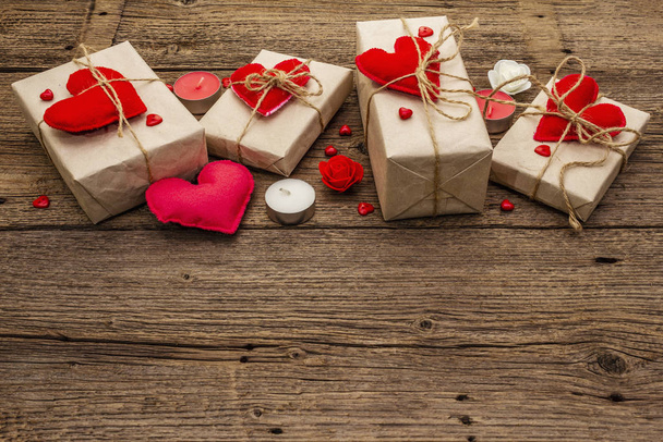 Zero marnotrawstwa. Walentynki lub Wedding ekologiczne opakowanie. Świąteczne pudełka w papierze rzemieślniczym z czerwonymi sercami filcowymi. Vintage drewniane tło - Zdjęcie, obraz
