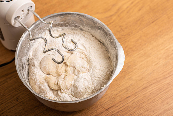 Hand mixer and a metal bowl with dough. - Photo, Image