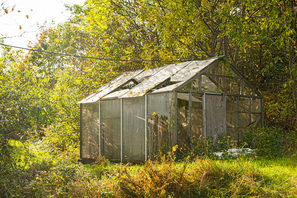 Een oud groen huis in een uitgestrekte groene tuin. - Foto, afbeelding