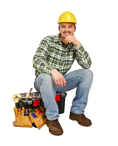 young handyman sit on his toolbox isolated on white  - Foto, Imagen