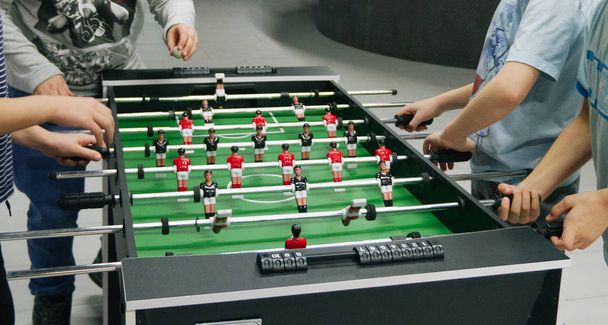 Szczęśliwy chłopcy grać tabeli soccertable mecz piłki nożnej, Piłka nożna z czerwonymi i czarnymi graczami - Zdjęcie, obraz