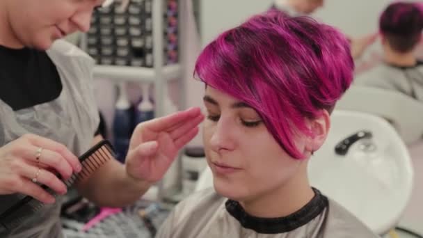 Professional hairdresser woman styling girl after dyeing hair. - Footage, Video
