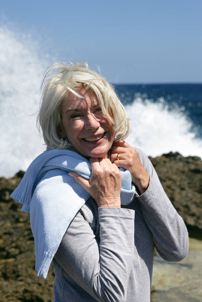 Elderly woman smiling at the sea - Photo, Image
