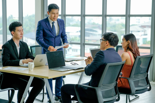Grupa pracy zespołowej azjatyckich biznesmenów dyskutować podczas spotkania dla pracy biznesowej w pokoju. - Zdjęcie, obraz