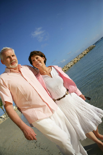 Senior couple strolling on the beach - Zdjęcie, obraz