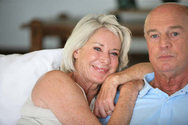 Senior couple sitting in a sofa - Φωτογραφία, εικόνα