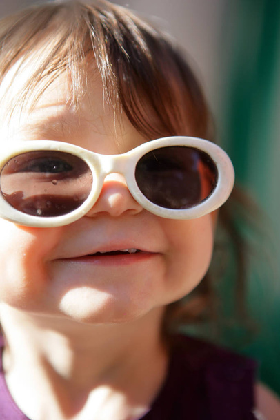 Portrait of a smiling little girl wearing sunglasses - Fotografie, Obrázek
