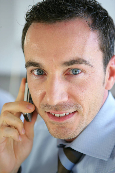 Portrait of a smiling man in a suit calling with mobile phone - Foto, Imagem