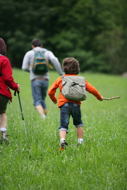 Jelenlegi fiú a fűben visel hátizsák - Fotó, kép