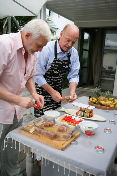 Senior Men preparing fish kebabs terrace - Fotografie, Obrázek