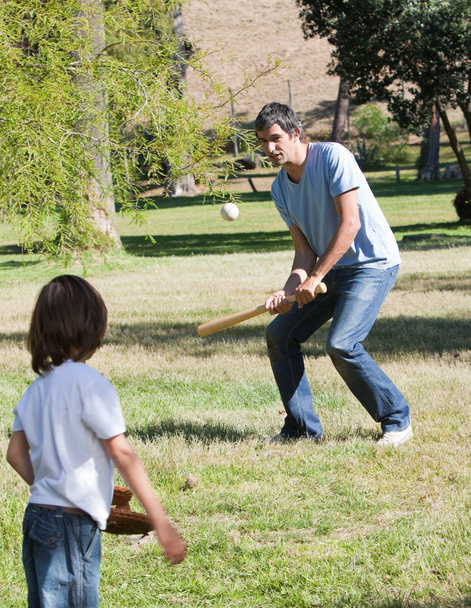 Athletic father playing baseball with his son in the park - Φωτογραφία, εικόνα