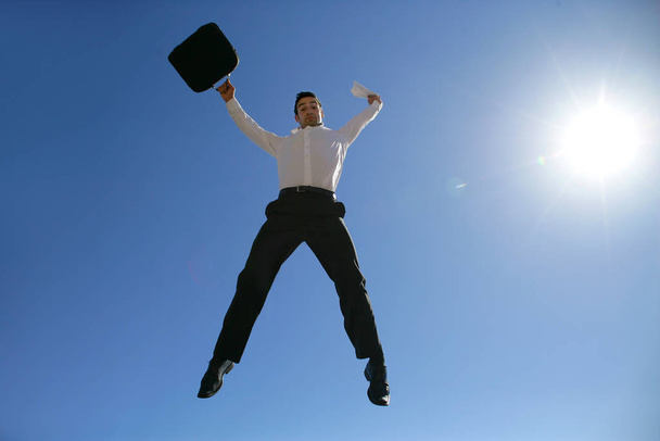 man in suit with briefcase jumping in the air face - Фото, изображение