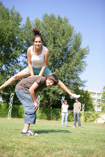 Young girl doing leapfrog with a boy - Φωτογραφία, εικόνα