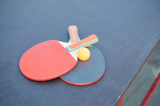 raquettes et ballon sur la table de ping-pong dans la cour de sport extérieure. Concept de sport actif et d'entraînement physique
 - Photo, image