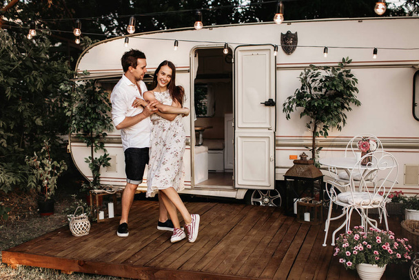 beautiful young couple having fun, young people near their mobile home - Foto, afbeelding