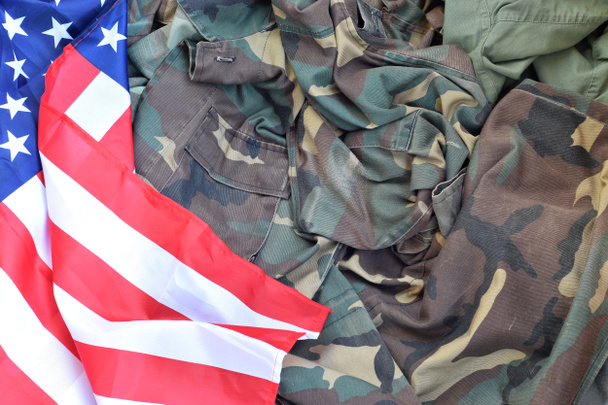 Bandera de los Estados Unidos de América y chaqueta militar plegada. Banner de fondo conceptual de símbolos militares para fiestas patrióticas americanas
 - Foto, Imagen