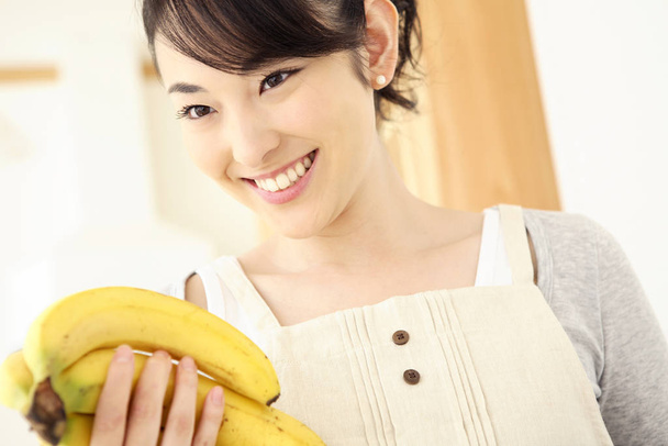 Woman grasping a banana - Φωτογραφία, εικόνα