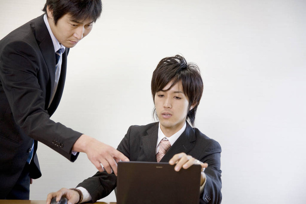 Japanese office workers having breif meeting - Foto, Imagen