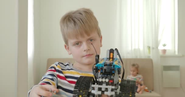 Mały chłopiec testujący samochód robotyki w domu. - Materiał filmowy, wideo
