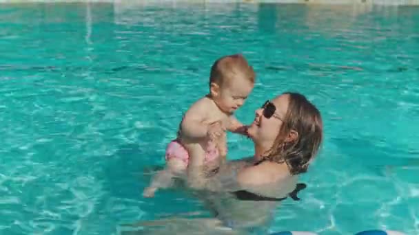 Jovem mãe brincando com crianças na piscina
 - Filmagem, Vídeo