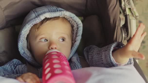 Menina bebê bebendo leite com uma garrafa
  - Filmagem, Vídeo