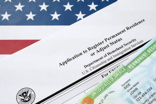 I-485 Застосування для реєстрації постійного проживання або коригування форми статусу та зеленої картки з dv-lottery лежить на прапорі США від Департаменту національної безпеки - Фото, зображення