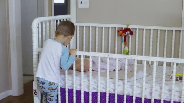 Lindo bebé tendido en la cama en casa con su hermano 4k
 - Imágenes, Vídeo