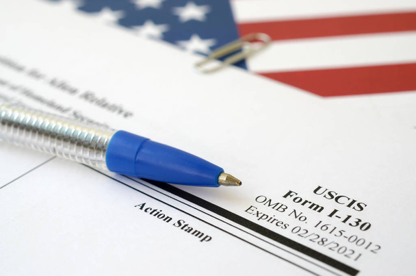 I-130 Petição para alienígena formulário em branco relativo encontra-se na bandeira dos Estados Unidos com caneta azul do Departamento de Segurança Interna
 - Foto, Imagem