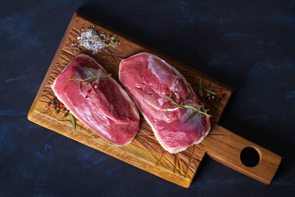 Raw fresh meat, duck breast fillet on wood chopping board. View from above, top view - Фото, изображение