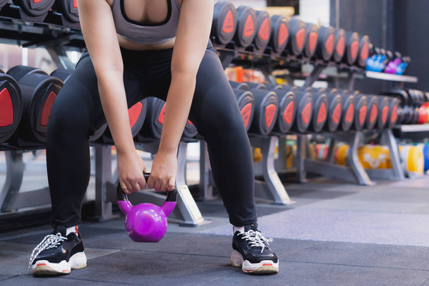 Young sporty woman doing Sumo squats with kettlebell in gym. Spo - Photo, Image