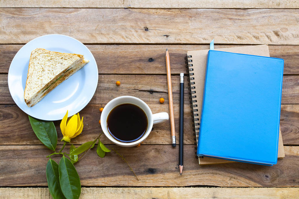 Планувальник ноутбуків для бізнесу працює зі сніданком гаряча кава еспресо, аранжування з бутербродом плоский стиль лежачи в офісі на фоні дерев'яного
 - Фото, зображення