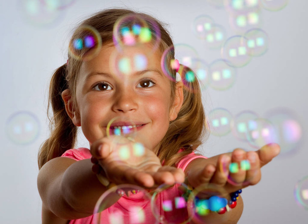 Young girl catching bubbles - Фото, зображення