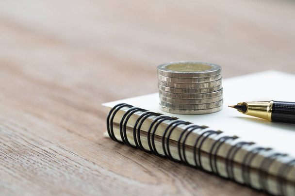  Notizbuch und Stift bereiten Planungsspargeld von Münzen vor, inve - Foto, Bild
