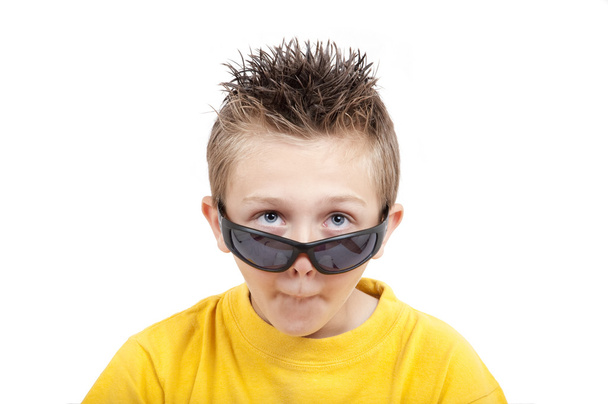 Verrücktes grimmiges Kind mit Sonnenbrille, isoliert auf weißem Hintergrund - Foto, Bild