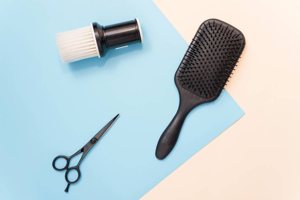 Flat lay composition with professional hairdresser tools on pastel color blue and beige background. Tools for hair styling. Brush for brushing hair, comb for combing and scissors for cutting on a past - Фото, зображення